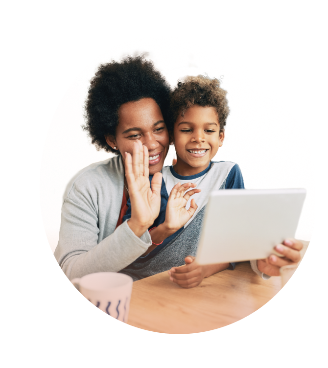 Maman souriante partageant un moment joyeux avec son enfant en visioconférence.
