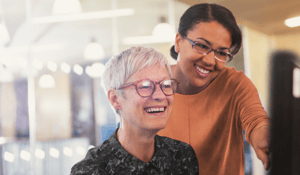 Two woman looking at computer intergenerational with bg 1-1