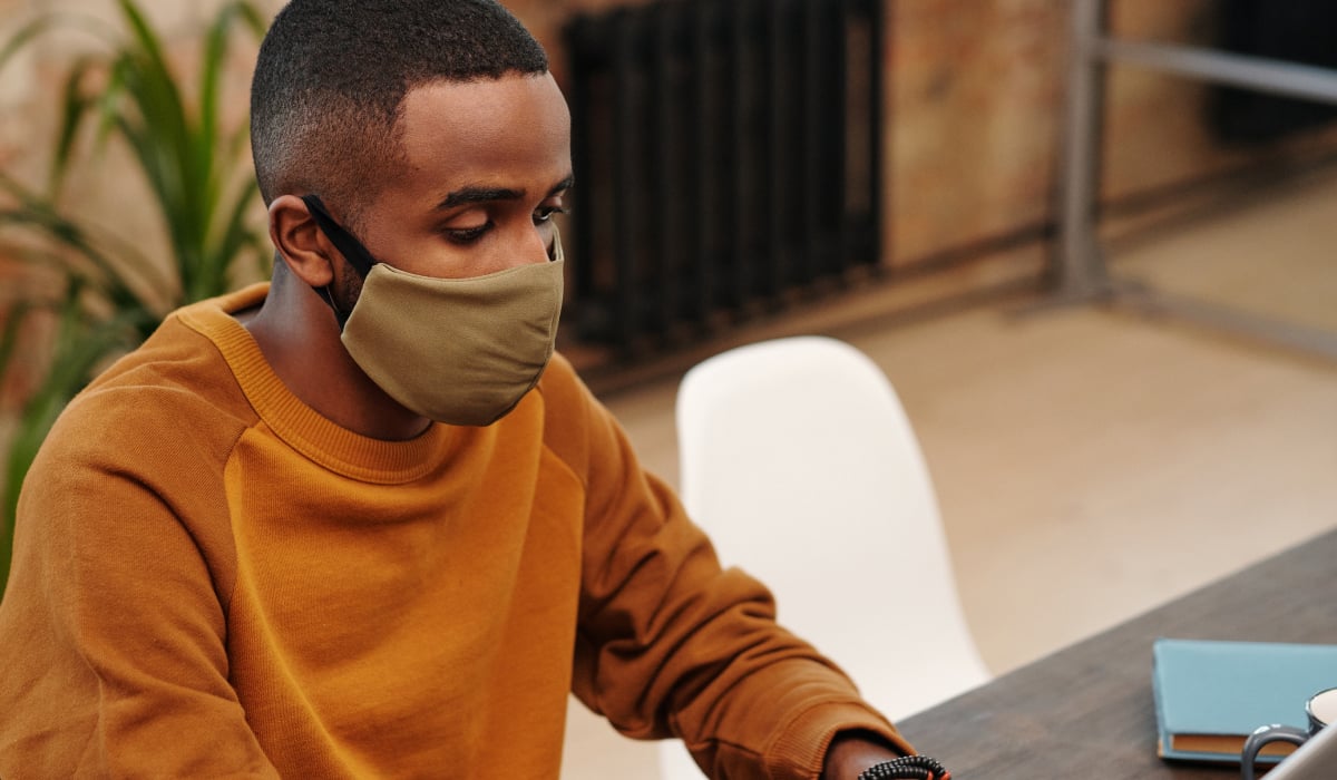 Man with mask at laptop