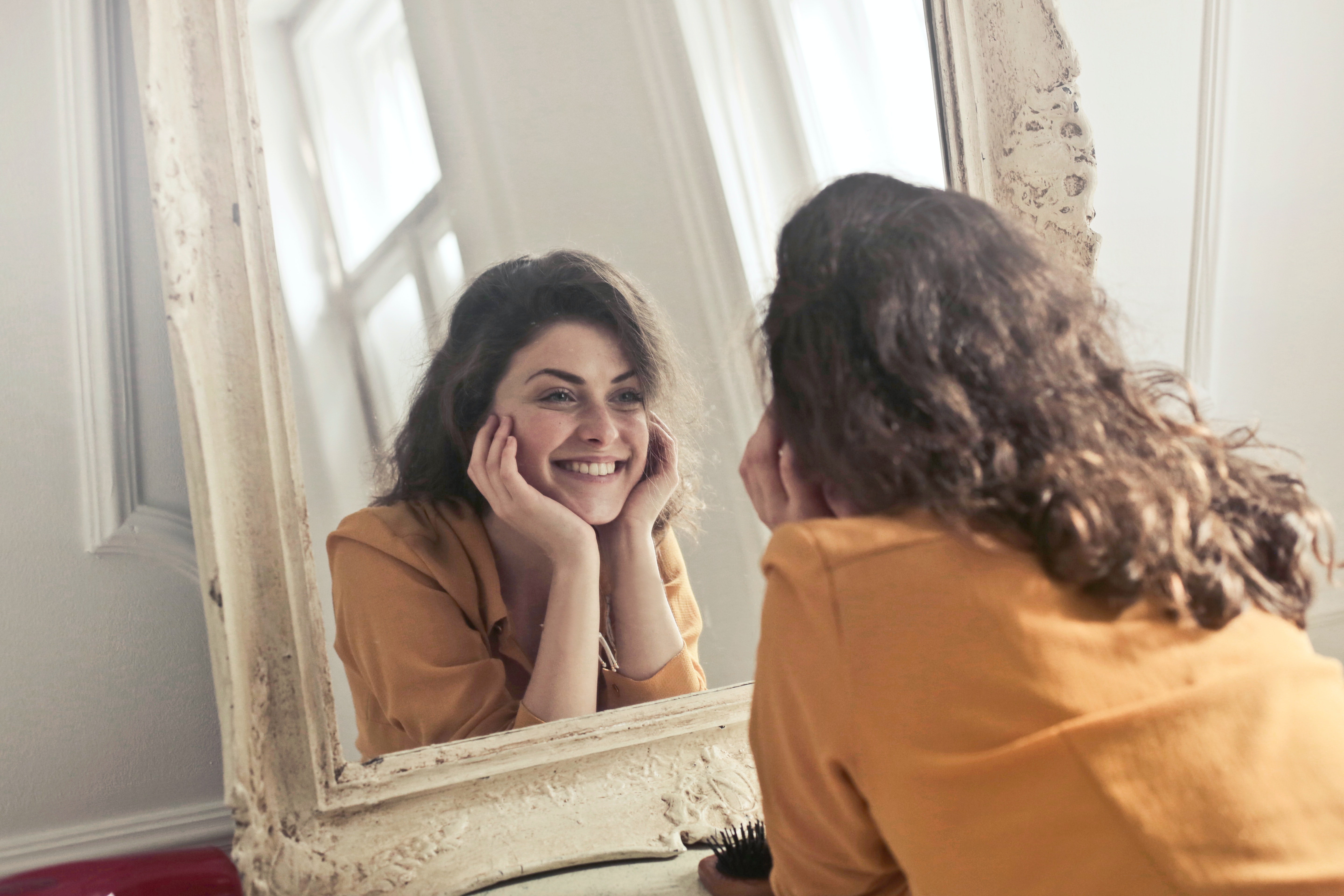 Women smiling in front of a mirror 